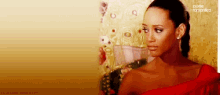 a woman in a red dress is standing in front of a gold wall with zone romantica written on the bottom right