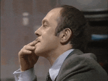 a man in a suit and tie is thinking about something