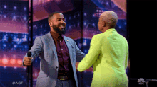 a man in a suit is hugging a woman in a neon yellow jacket