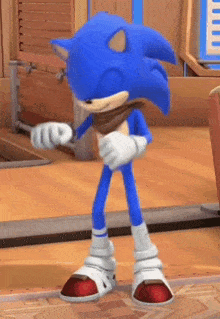 sonic the hedgehog is standing on a wooden floor in a room .
