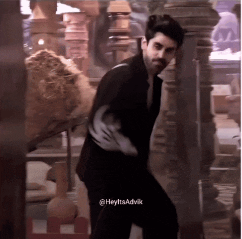 a man in a black suit is dancing with the hashtag heyitsadvik on the bottom right