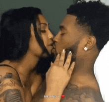 a man and a woman are kissing each other in bed .