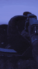 a blurred image of a person holding a gun with a blue background