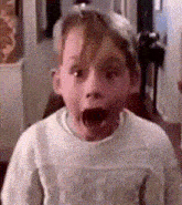a young boy is making a surprised face with his mouth open