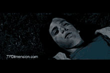 a black and white photo of a person laying in the grass with a website called tfdimension.com