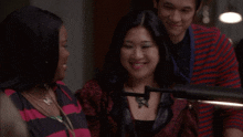 a woman wearing a necklace with a butterfly on it is smiling