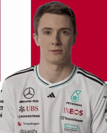a man wearing a white shirt with sponsors such as ubs and ineos on it