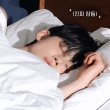 a young man is sleeping in a bed with chinese writing on the bottom