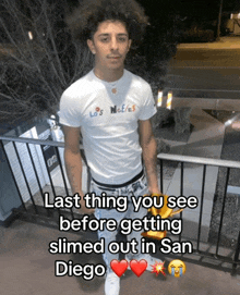 a young man in a los angeles t-shirt holds a bag of french fries