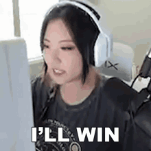a woman wearing headphones is sitting in front of a computer screen and says `` i 'll win '' .