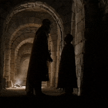 a man in a cape and a crown holds a sword in a stone tunnel