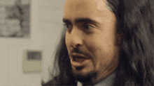 a close up of a man with long hair and a beard