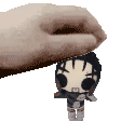 a hand is holding a small figurine of a person .