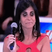 a woman is holding a microphone and making a funny face .