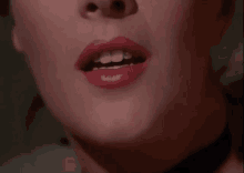 a close up of a woman 's mouth with red lipstick on it .