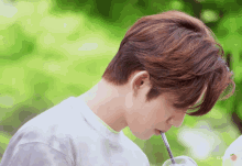 a close up of a person drinking through a straw with the word ilk on the bottom right