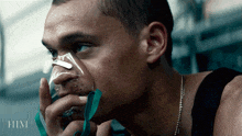 a man is wearing an oxygen mask and the word him is on the bottom