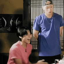 a man in a blue shirt is standing next to a woman in a pink shirt .