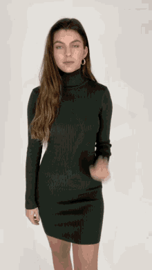 a woman wearing a green turtleneck dress