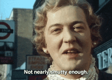 a woman says " not nearly smutty enough " in front of a sign that says stop