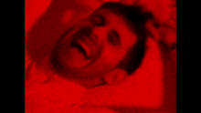 a man is screaming in a red background with his mouth open