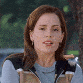 a close up of a woman wearing a sweater and a vest