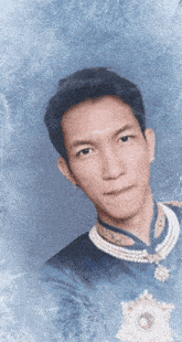 a man in a blue and gold outfit with pearls