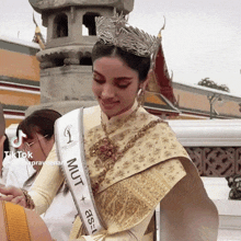 a woman wearing a crown and a sash that says mult