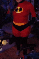 a woman in a red sweater is standing in front of a poster that says the incredibles