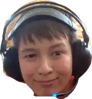 a boy wearing headphones and a microphone smiles for the camera