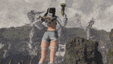 a woman holding a gun stands in front of a mountain