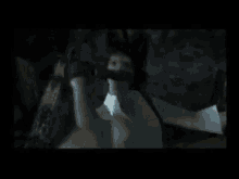 a man is holding a gun in a video game while standing in a dark room .
