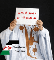 a man holding a sign that says western sahara in front of his face