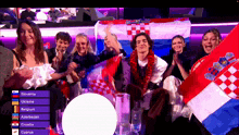 a group of people holding flags in front of a screen that says slovenia ukraine belgium azerbaijan croatia and cyprus