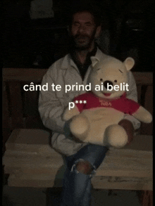 a man holding a winnie the pooh teddy bear with a red shirt