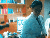 a man in a lab coat stands in front of a computer