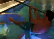 a man in a hurley swim trunks is sitting in a pool