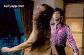 a man and woman are dancing in a room .