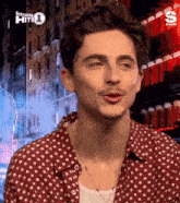 a man wearing a red polka dot shirt with siriusxm hits 1 on the bottom