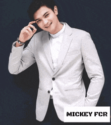 a man wearing a white suit jacket with the word mickey fcr below him