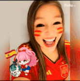 a girl wearing a red adidas jersey with a spanish flag painted on her cheeks