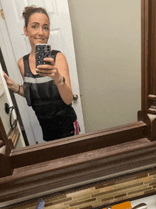 a woman is taking a picture of herself in a mirror