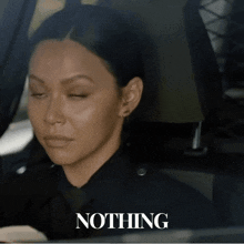 a woman in a police uniform is sitting in a car and the word nothing is on the bottom right