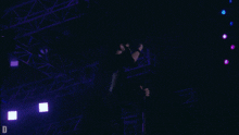 a man singing into a microphone with the letter d in the lower right corner