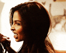 a woman is sticking her tongue out while talking on a phone