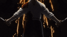 a man with a mustache is holding a pair of swords in his hands .