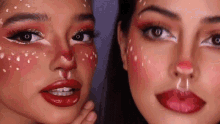 two women are standing next to each other with their faces painted to look like reindeer .