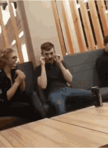 a man and a woman are sitting on a couch and the man is wearing glasses