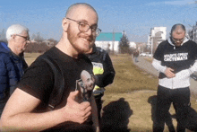 a man giving a thumbs up wearing a black shirt that says " mladite cpeuy sistemata "