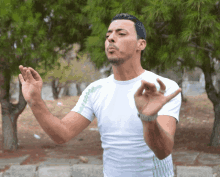 a man wearing a white shirt with the word adidas on the side